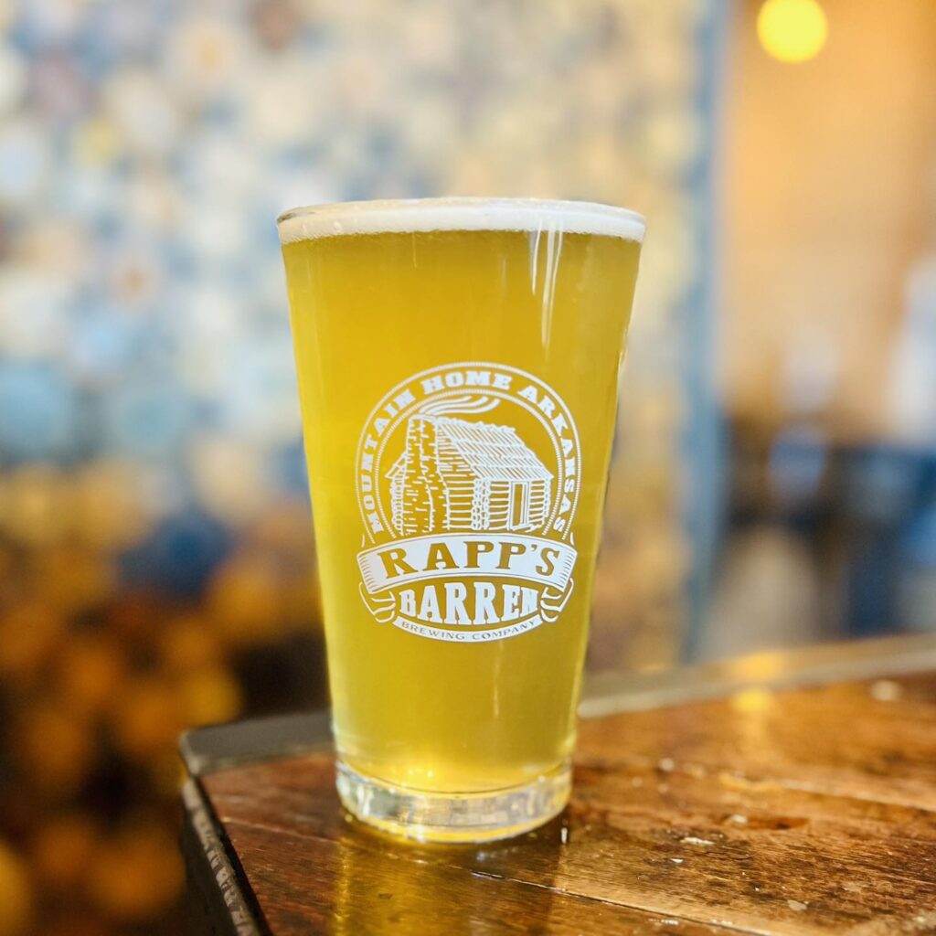 Glass of light colored beer with a Rapp's Barren Brewing Company logo on it in white