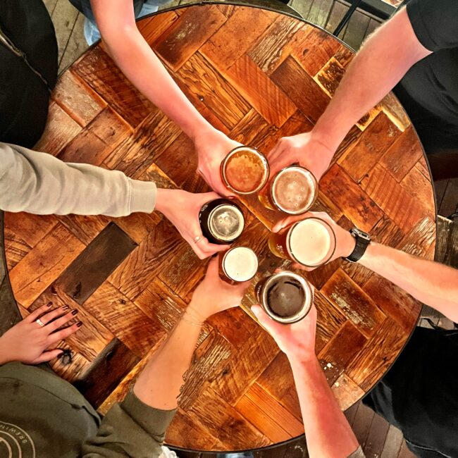 Six glasses of beer from six different arms coming together in the middle to showcase the different colors and flavors of beer available at Rapp's Barren Brewing Company in Mountain Home Arkansas