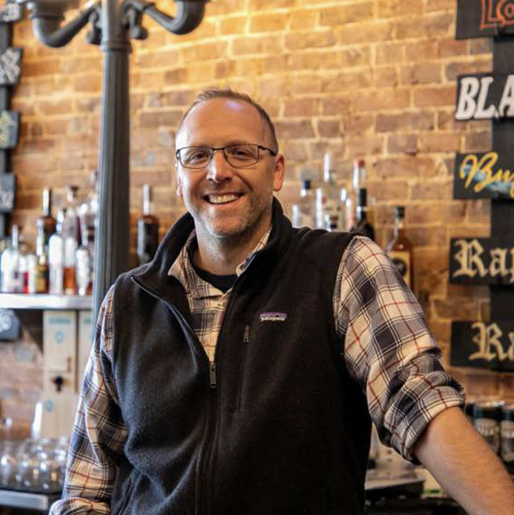 Man standing behind the bar with a smile on his face at Rapp's Barren Brewing Company in Mountain Home Arkansas